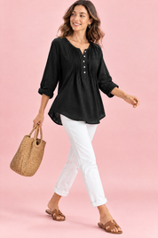 Blouse noire en coton à col rond et patte de boutonnage plissée | Vue en mouvement | Lounelle Paris